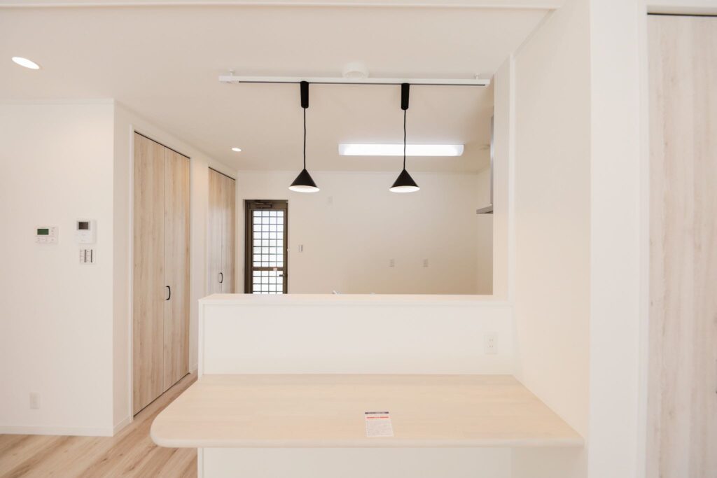 山梨平屋専門店が施工した、白を基調とした明るいキッチンスペース。カウンターと黒いペンダントライトがアクセントの平屋住宅。
