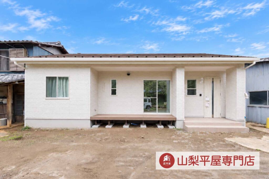 玄関ドアと外壁を同系色でまとめた山梨平屋住宅の外観施工事例